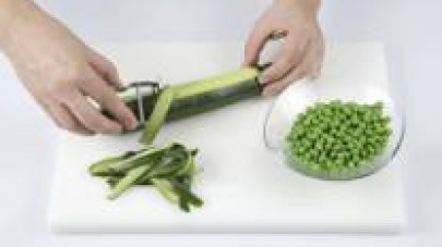 Pelate la zucchina e usate solo la pelle. Mettete i piselli verdi in un recipiente e aggiungete le strisce di zucchina. 