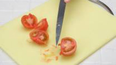 Pelate i pomodori e tagliateli a metà. Privateli dei semi e tagliateli a dadini piccoli. 