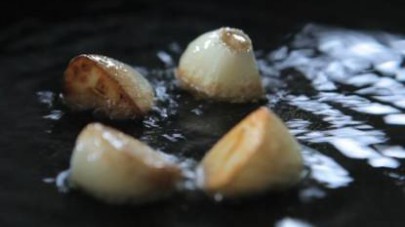 Nella stessa padella, dorate gli spicchi d’aglio, tagliati in due parti, con un filo di olio.