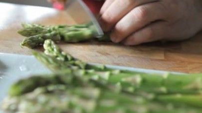 Rimuoviamo le estremità legnose dei quattrocento grammi di asparagi e li laviamo bene. Tagliamo le punte a pezzettini nella misura di due a quattro centimetri.