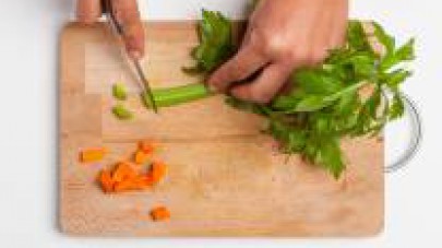 Tagliate finemente il sedano e le carote e metteteli a scaldare in padella con 2 cucchiai di olio extravergine di oliva. Unite la carne e lasciatela rosolare da entrambi i lati; quindi unite 1 Dado St