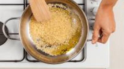 In un’altra padella, fate soffriggere il riso con 1 cucchiaio di olio extravergine di oliva