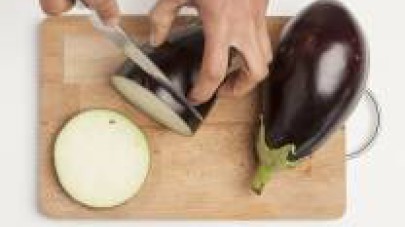Mondate le verdure; tagliate a cubetti le melanzane e affettate finemente lo scalogno. Soffriggeteli in un wok con 2 cucchiai di olio extravergine di oliva.