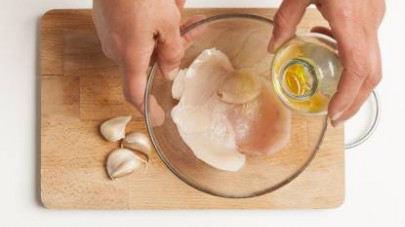 Disponete le fettine di petto di pollo in una ciotola e versatevi sopra la marinatura.