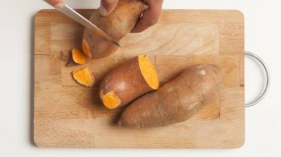 A parte, pelate le patate dolci americane e tagliatele a fettine sottili aiutandovi con un pela patate.