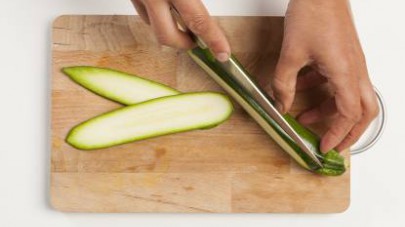 Lavate e mondate le zucchine; quindi, disponetele su un ripiano e tagliatele in fette non troppo spesse. Scaldate la griglia e cuocete le verdure per qualche minuto.  Accendete il forno a 180° C.