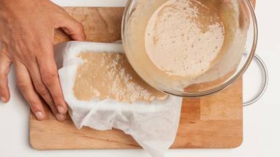 Versate il composto di farina di castagne in uno stampo da plumcake ricoperto di carta da forno e cuocete in forno il castagnaccio per 10 min. a 180° C. 