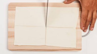 Tagliate la pasta sfoglia in rettangoli da 10 cm di lato e adagiateli su una teglia rivestita con carta da forno.