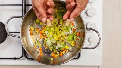 In una padella, fate soffriggere i porri con la carota in 2 cucchiai di olio extravergine di oliva.