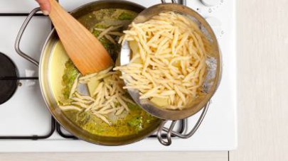 Nel frattempo, in una padella, scaldate 4 cucchiai di Tigullio Gran Pesto Delicato Star con 2 cucchiai di olio extravergine di oliva. Unite la pasta e le patate e mescolate bene.