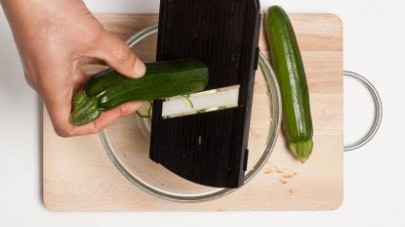 Lavate le zucchine e affettatele a rondelle sottili con una mandolina.
