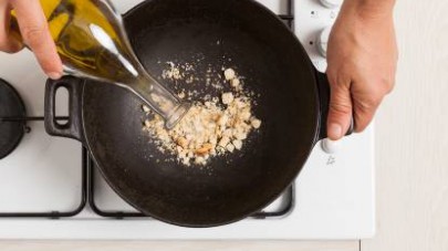 Tostate il pane sminuzzato grossolanamente in un wok con poco olio extravergine di oliva.