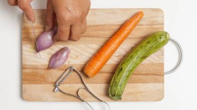 Pelate lo scalogno per rimuovere i primi strati secchi, poi lavate con attenzione anche le carote e le zucchine.